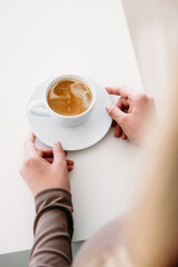 Hands holding a cup of fresh coffee