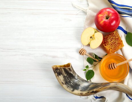 A traditional Rosh Hashanah spread featuring a shofar, apples, and honey on a white wooden surface with a striped cloth. - Powered by Adobe