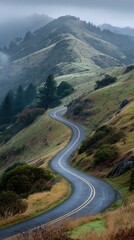 Fototapeta premium Winding mountain road through misty hills