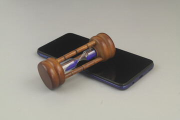 Lifetime of smartphone concept. Hourglass on smartphone on grey background.	