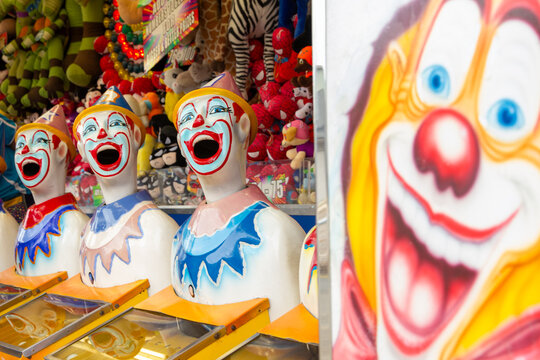 Row of brightly coloured clown heads at carnival sideshow alley