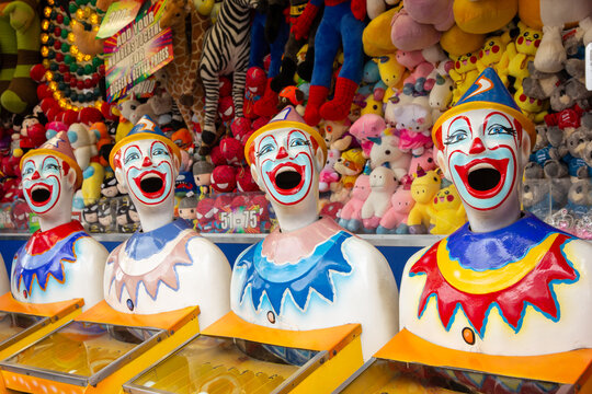 Row of brightly coloured clown heads turning at country show