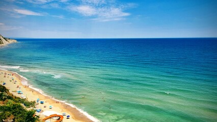 Beachgoers enjoy a sunny day at a scenic coastal location with clear blue waters and vibrant umbrellas