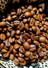 Brown coffee beans in the bowl. Close up. 