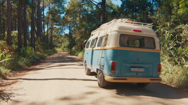 Hippie bus with surfing boards on its roof moves on the street in Brazil