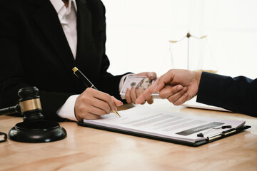 Two businessmen shake hands in an office, symbolizing agreement, partnership, and legal settlement. A gavel, scales of justice, and documents on the desk represent law, judgment, and professional trus