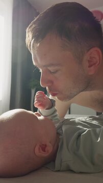 Three month old baby boy playing with father close up. Tender family morning in warm sunlights. Happy Parenthood. Unconditional Love of Dad and Child