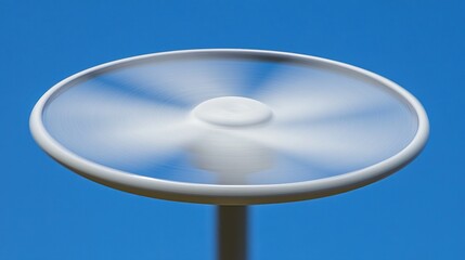 Capturing motion: A spinning white disc against a vibrant blue sky backdrop showing dynamism and