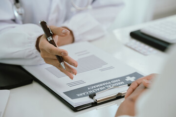 Fototapeta premium A doctor consults with a patient in a healthcare office, reviewing documents and providing medical advice, diagnosis, and treatment during a professional hospital or clinic appointment.