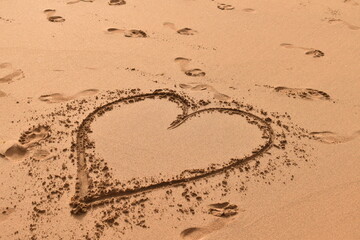 Heart in the sand near the sea — romantic beach moment symbolizing love and summer escape.