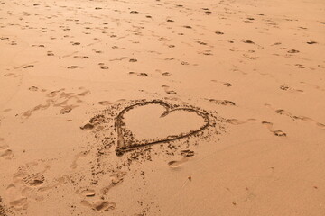 Heart drawn in the sand on a beach — symbol of love, romance, and seaside memories.