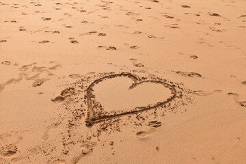 A heart symbol drawn on sandy beach — capturing a fleeting romantic moment by the sea.