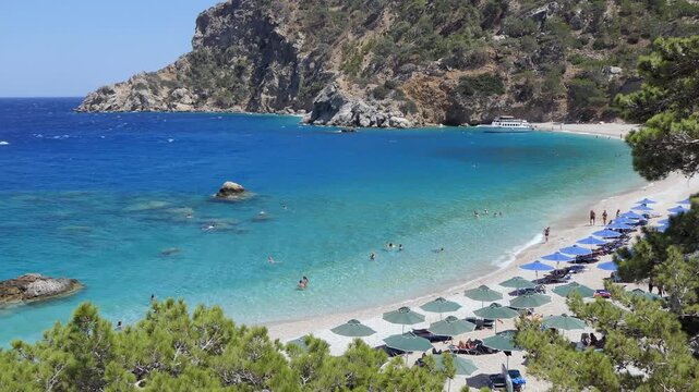 View of Apella beach on Karpathos island in Aegean Sea, Greece. Greek destination on Mediterranean Sea with people and tourists swimming