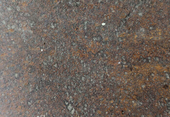 Rusty metal surface with textured spots and orange-brown patina, industrial grunge background.