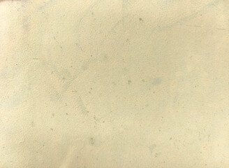 Beige textured wall surface with subtle stains and marks, minimalistic background for design.