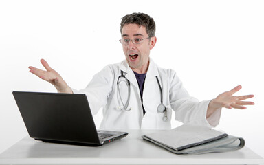 Medical Admin: Amazed Doctor. A surprised doctor sitting at his desk wearing a white lab coat and a stethoscope. He gestures with his hands in disbelief or surprise at his computer.