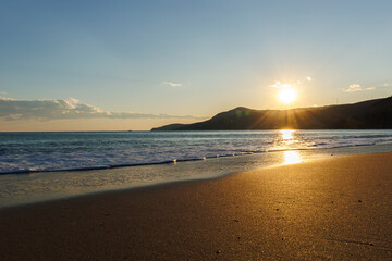 waves on the beach and sunset over the hill in Mersin