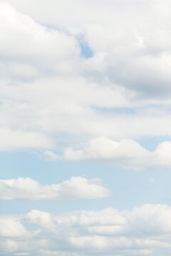 Scattered white clouds in soft blue sky