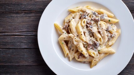 Creamy Penne Pasta. Top View of Italian Penne alla Norcina with Cream Sauce, Black Truffle, and Cheese on White Plate