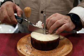 experto quesero rayando con ralladora girolle de queso un queso de oveja para hacer virutas