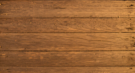 Close-up view of a rustic wooden surface featuring horizontal planks with visible grain and texture, creating a warm, natural background.