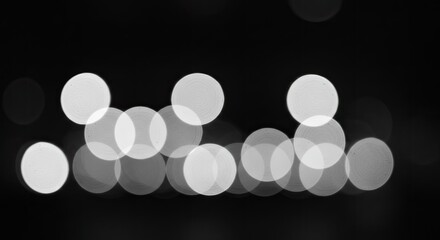 Abstract Bokeh Circles: Soft, Glowing, Monochrome Light on Black Background.