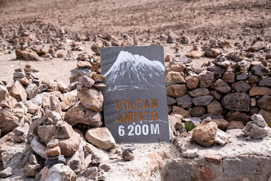 Schild des Vulkans Ampato in 6200 Metern H&ouml;he umgeben von Steinhaufen in den peruanischen Anden
