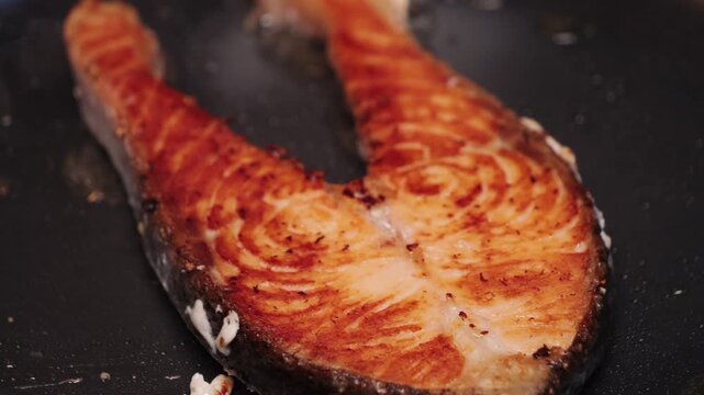 Improperly cooked salmon fillets at home, overcooked fish on a frying pan, close-up