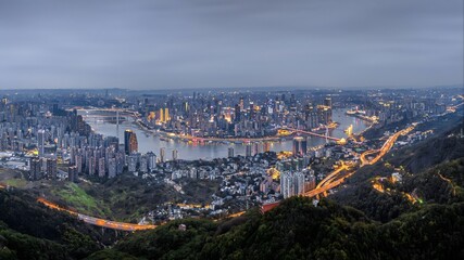 Obraz premium Aerial view of Chongqing China at night with magical city lights and river reflections creating breathtaking urban nightscape