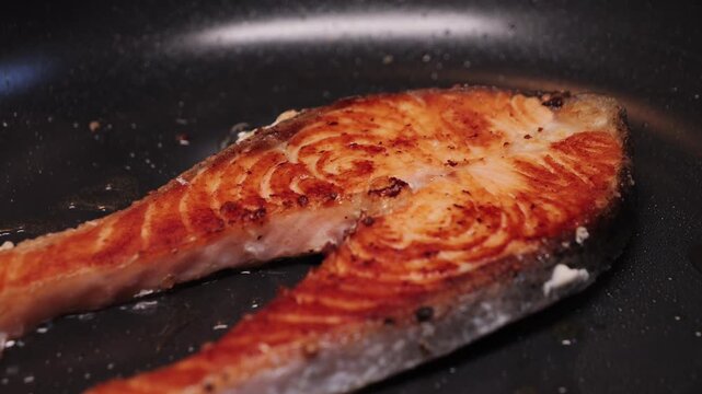 Improperly cooked salmon fillets at home, overcooked fish on a frying pan, close-up