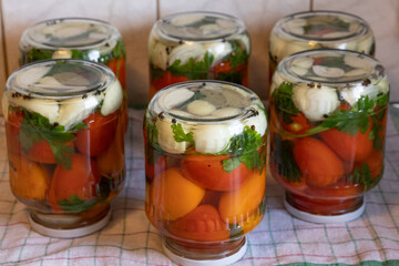 home preservation glass jars with pickled red and yellow tomatoes turned upside down with a lid