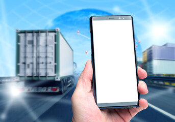 Hand holding smartphone with blank screen on background of cargo truck and containers, concept of logistics app, transport tracking, delivery technology. Logistics, Transportation, Technology.
