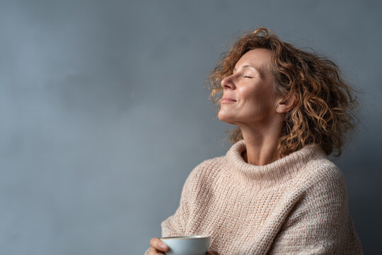 woman relaxing with steaming coffee mug in her hand exuding tranquility and warmth - Powered by Adobe