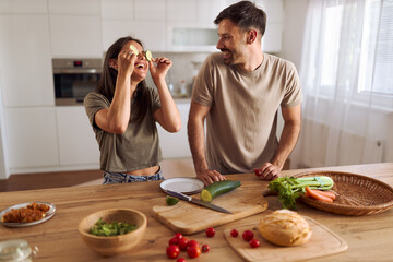 Happy couple  having fun while preparing a meal in the kitchen.
