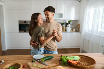 Happy mid adult couple having fun while dancing at dining room
