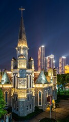 Obraz premium Aerial view of illuminated Gothic church against vibrant Chongqing city skyline at night, China