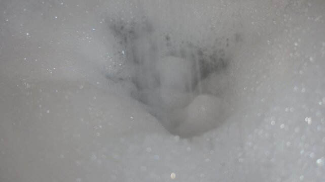 Close-up of soap bubbles with running water