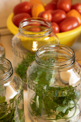 Glass jars filled with spices and onion rings prepared for tomato topping