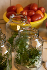 Fresh tomatoes will be added to glass jars filled with peppercorns, bay leaves, onions, and parsley for winter preservation