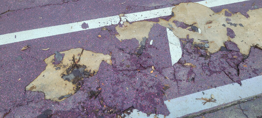 Parking lot surface shows significant wear with peeling paint and cracks, indicating deterioration and lack of maintenance, creating uneven and damaged appearance © Pixel Alchemist