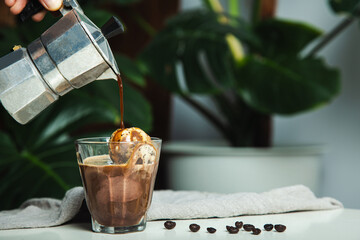 Affogato dessert made with Italian coffee, Moka pot pouring on ice cream vanilla homemade coffee.
