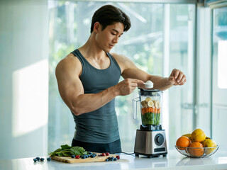 Athletic muscular man preparing smoothie with protein powder blender fresh fruits vegetables fitness nutrition lifestyle at home kitchen