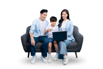 A family of three enjoys quality time looking at a laptop while sitting on a gray couch. The parents are both smiling and look happy as they are gathered with their child on PNG