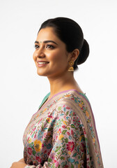 A graceful, mature Indian woman wearing a red and gold floral silk saree with traditional pearl necklaces and gold earrings