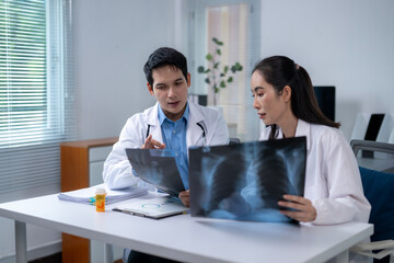 Two doctors are looking at a medical image of a patient's lungs