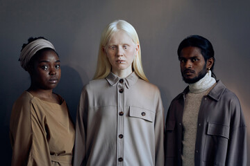 Horizontal medium studio shot of young Black, Caucasian women and Indian man wearing casual clothes...