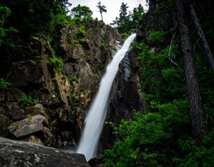 Obraz premium Waterfall cascading down rocky cliff face
