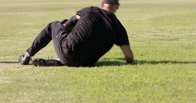 Teammate tossing baseball mid adult man spotting ball, diving with glove, fielding ball on field