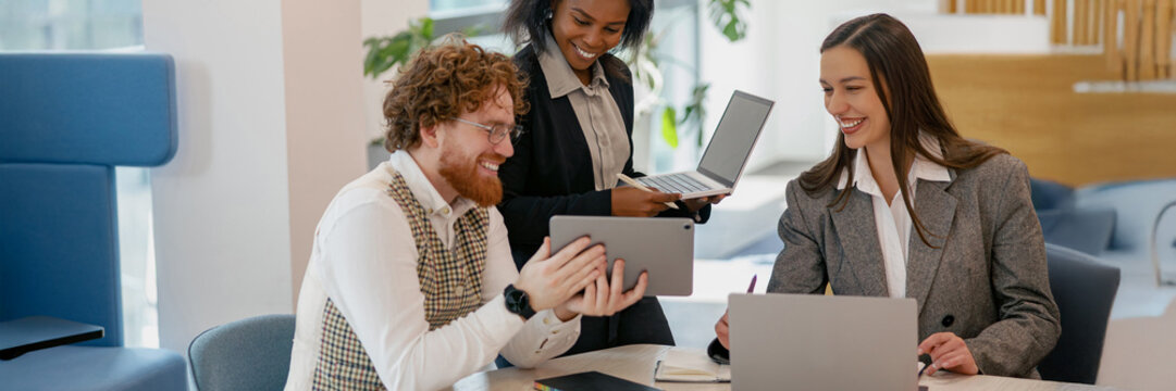 A diverse team in a modern office collaborates, exchanging innovative tech and fresh creative ideas - Powered by Adobe