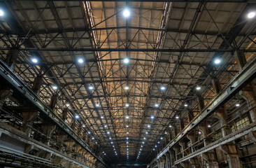 Massive Industrial Warehouse Interior with Steel Framework and Grid Pattern Lighting